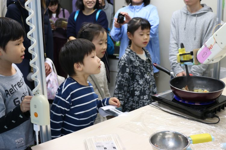 料理ロボットを見る子どもたち