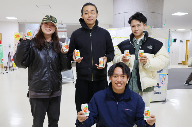 リンゴジュースを手にして笑顔の学生たち(文京町キャンパス)