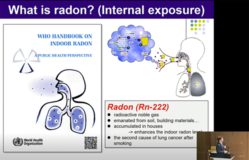 講演のスライドと講演中の床次教授(右下)