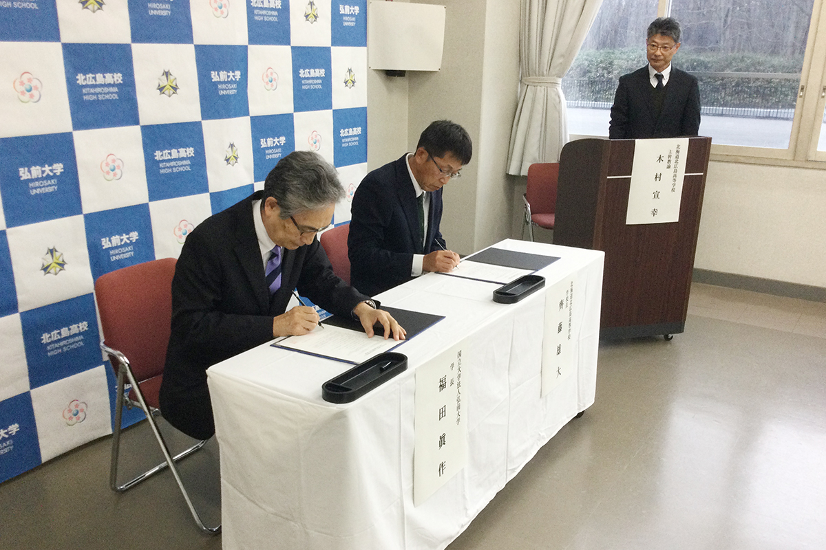 (左から)協定書に署名する福田学長と齊藤校長