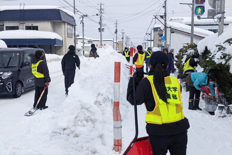 道路脇に積み上がった雪を除雪する様子