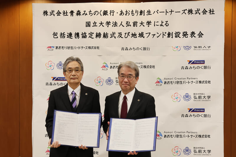 協定書を手にする福田学長(左)と石川頭取(右)