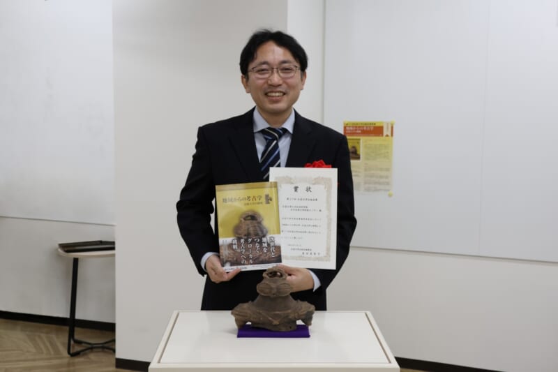 表紙を飾った遮光器土偶と受賞者代表
